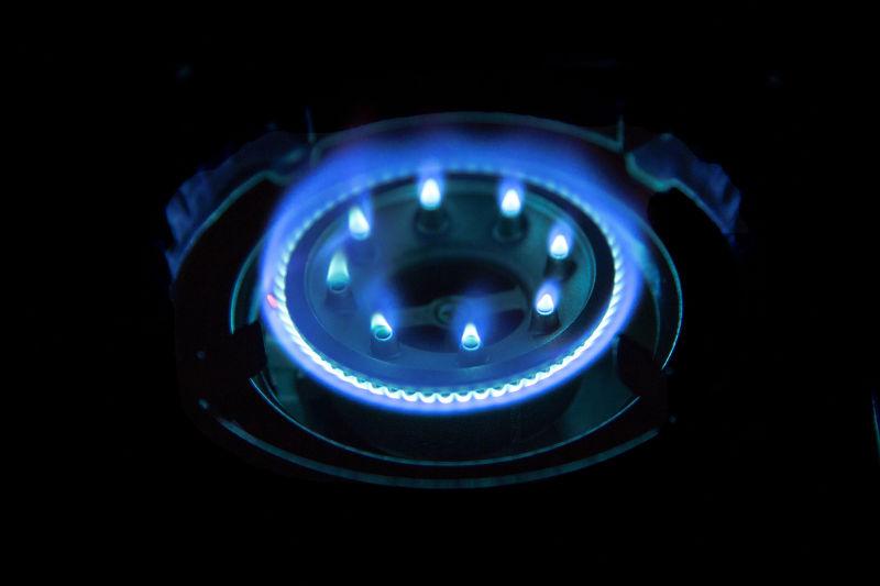 燃烧煤气炉滚刀蓝色火焰在黑暗中靠近黑暗的背景