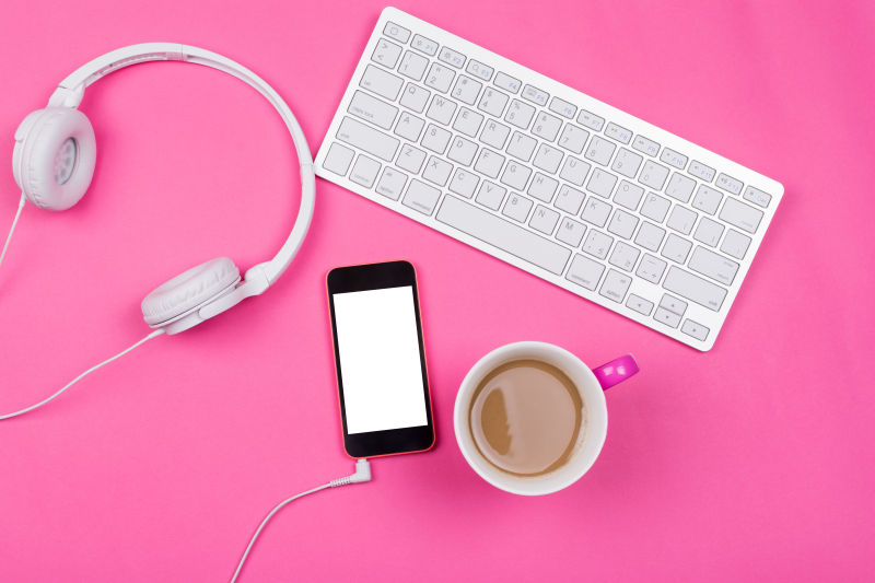 粉色桌面上的咖啡与键盘