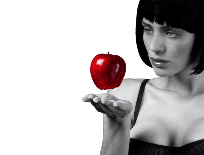 美丽的黑发女人看着手中的苹果