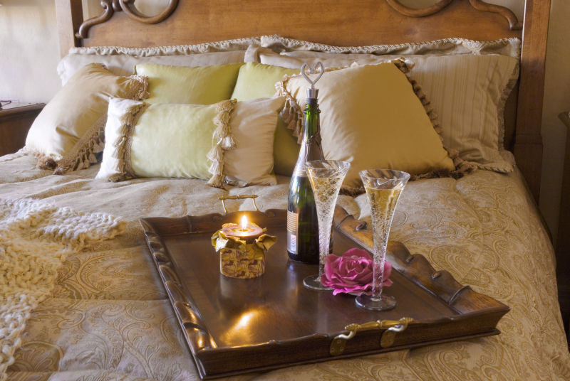 床上的托盘里放着香槟酒和蜡烛