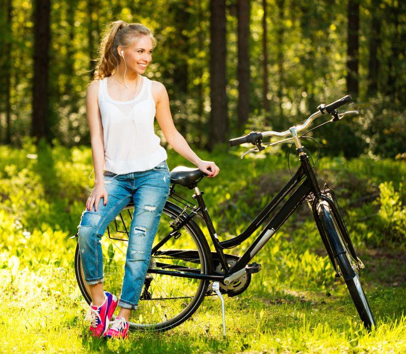 公园里的美女坐在自行车上微笑