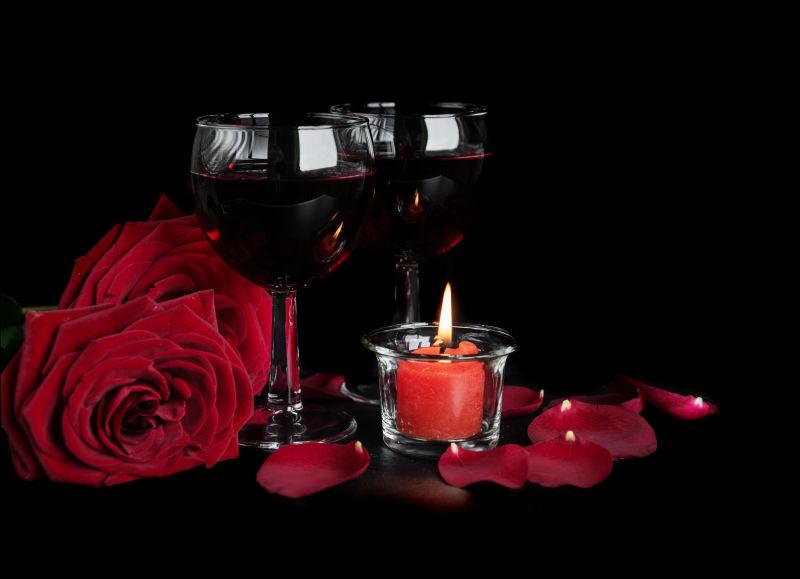 黑背景中的玫瑰和红酒