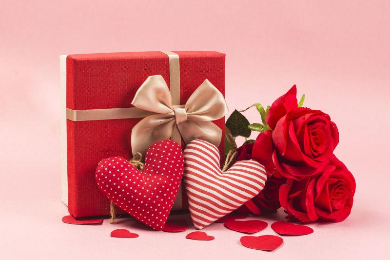 情人节礼物盒边的爱心饰品和玫瑰花束