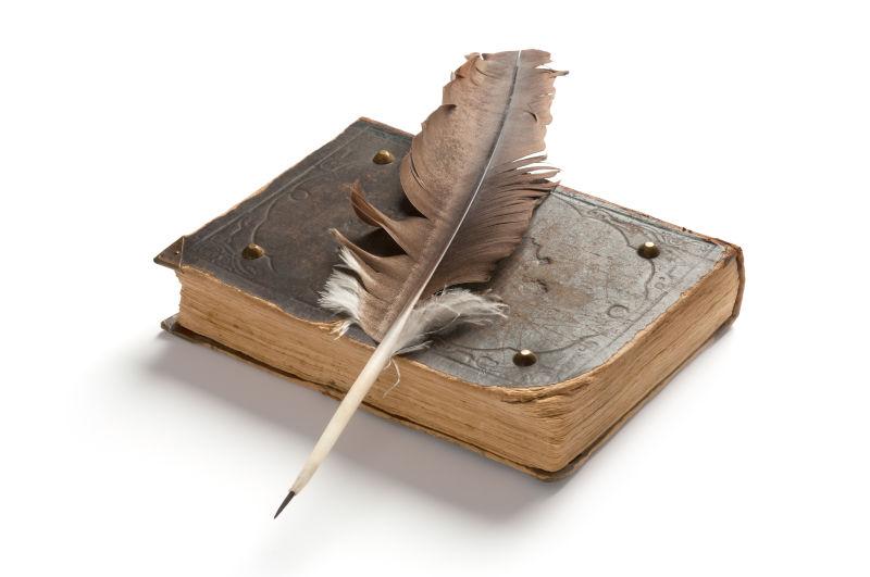 白色背景下的旧书和羽毛