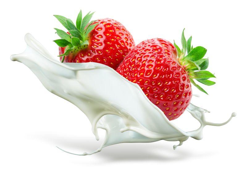 两个草莓掉进牛奶里在白色背景上