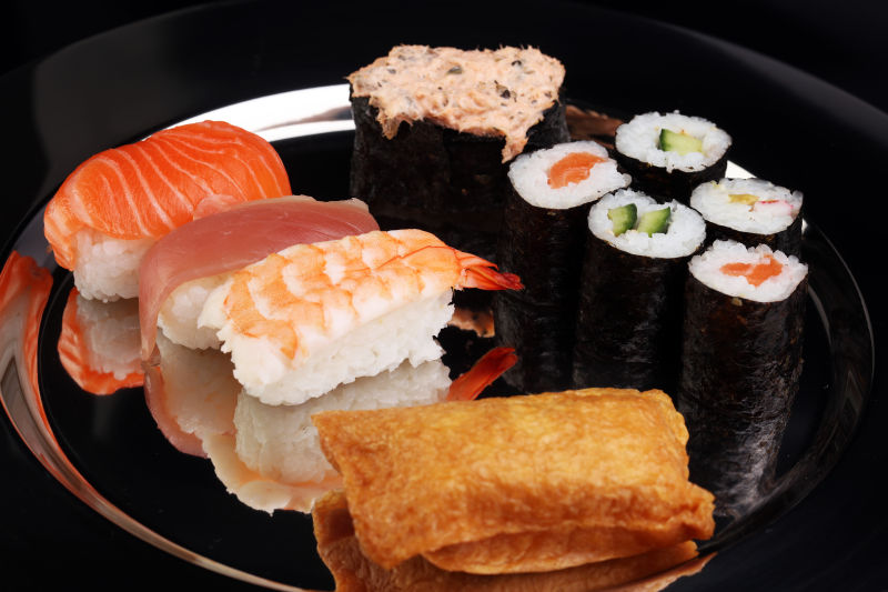 黑色盘子里的鲑鱼寿司卷