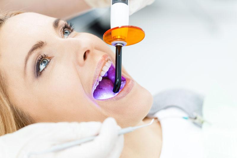 在牙科诊所做紫外线检查的女人