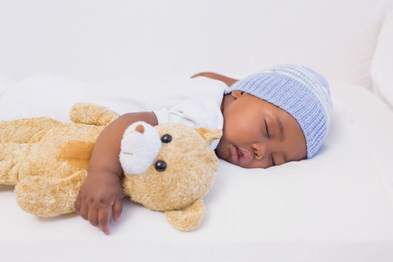抱着小熊玩偶睡觉的婴儿