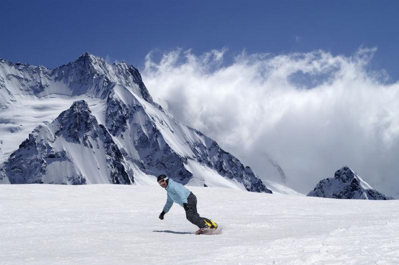 蓝天白云背景下在雪地上滑动的滑雪者