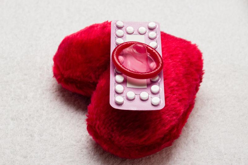 红心型小枕头与口服避孕药和避孕套
