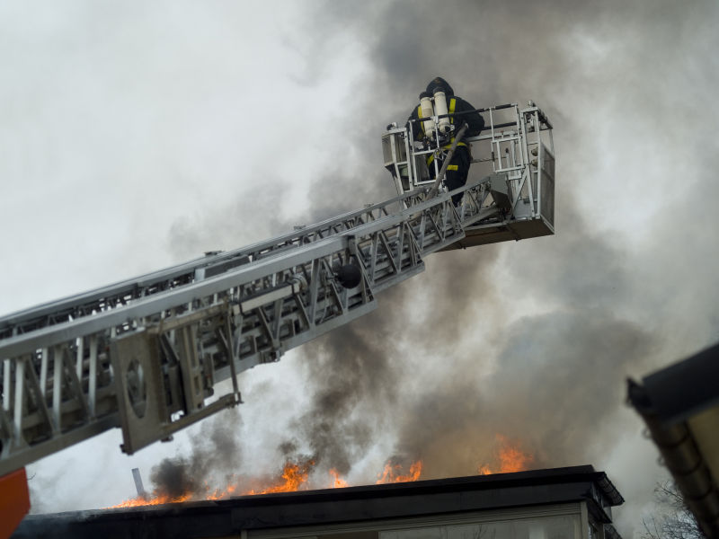 在梯子顶上工作的消防员