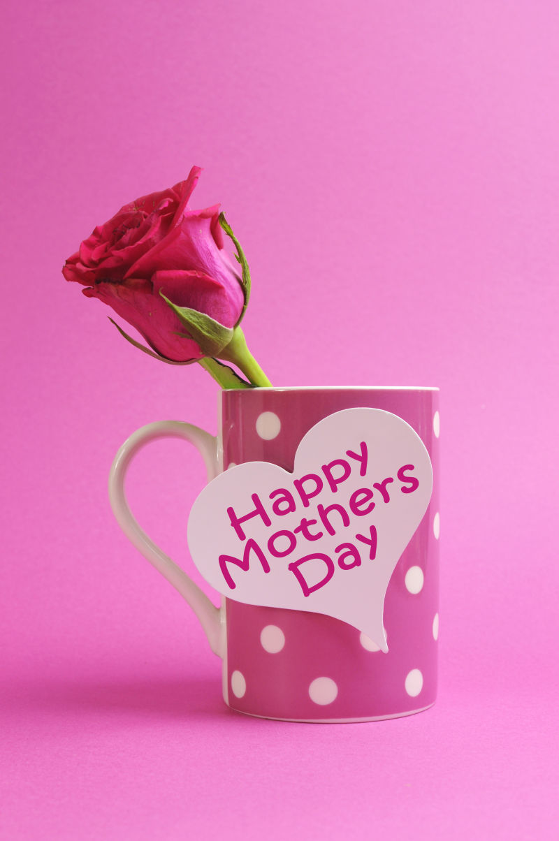 快乐的母亲节贺卡点缀粉红波尔卡点咖啡杯里的粉红色玫瑰花