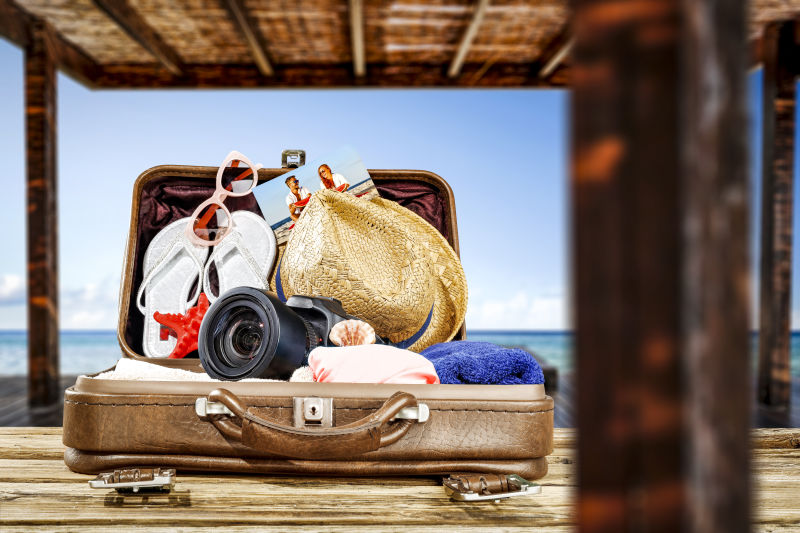 木板上的夏季旅游行李箱
