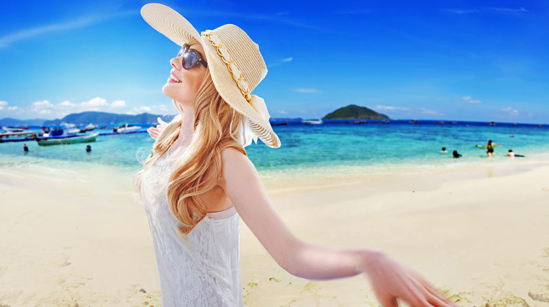 美丽的金发女郎在热带海滩上嬉戏玩耍