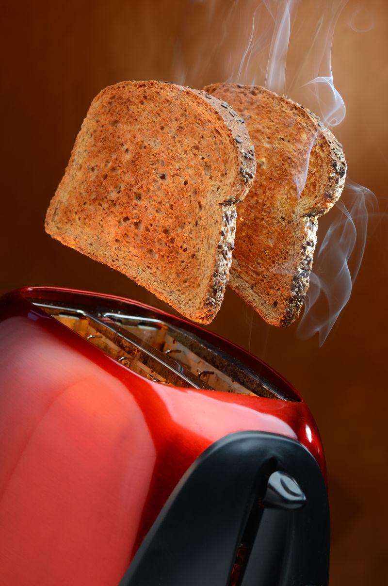 烤面包机和烤出的两片金棕色面包