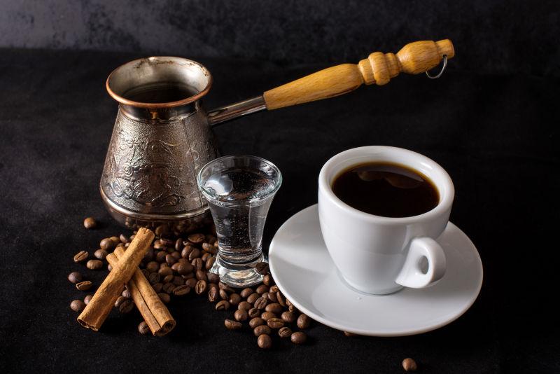 黑暗背景下的一杯水和土耳其咖啡