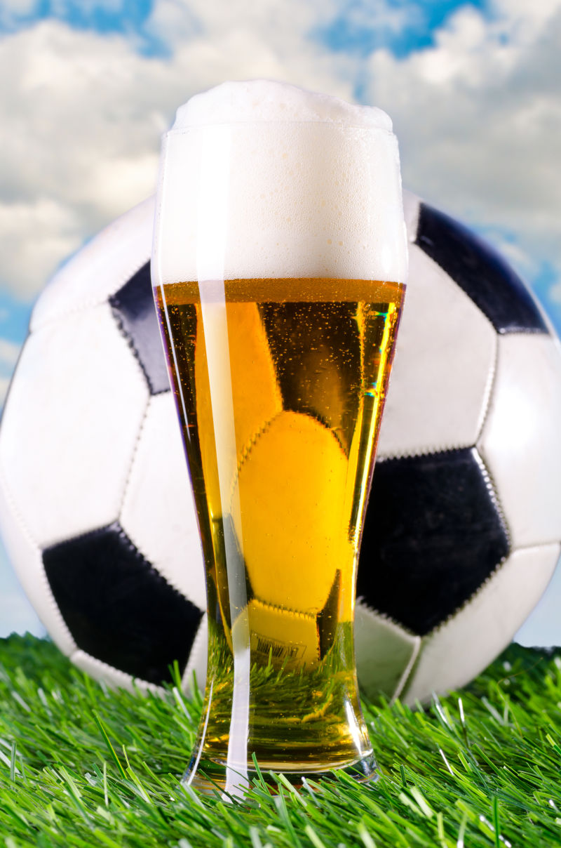 蓝天下草地上的啤酒与足球