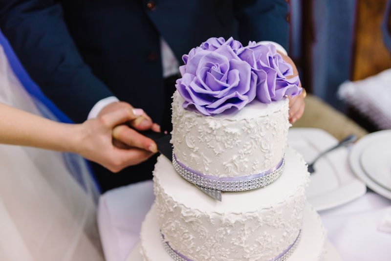 新娘和新郎用刀切婚礼蛋糕