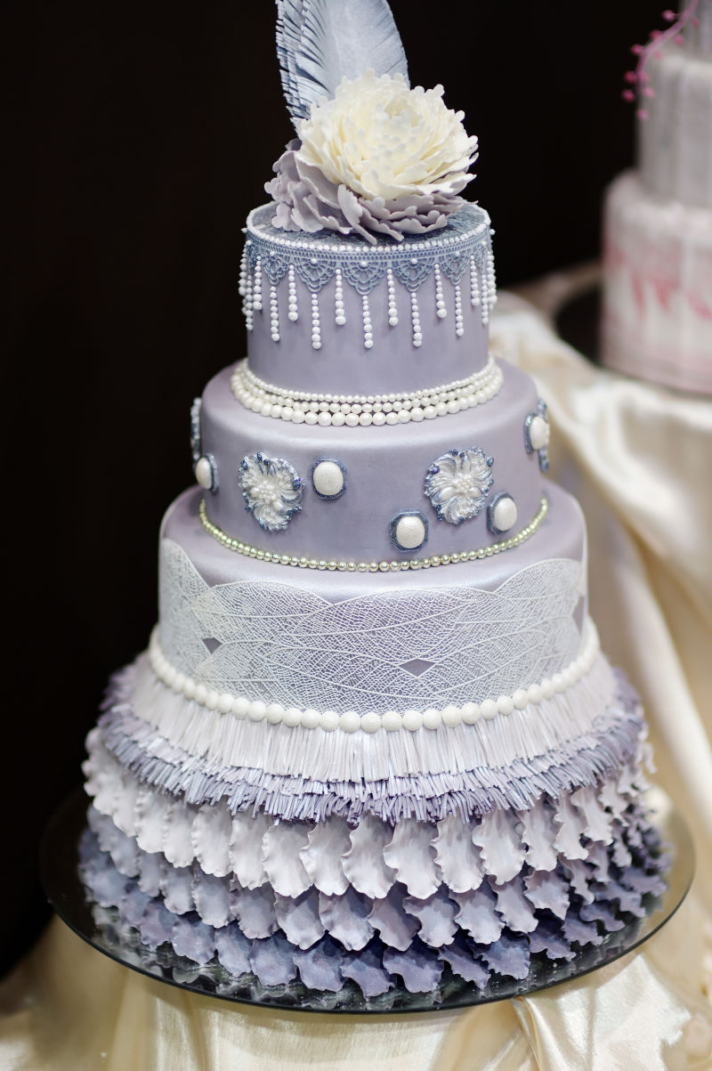 鲜花和珍珠装饰的紫色婚礼蛋糕