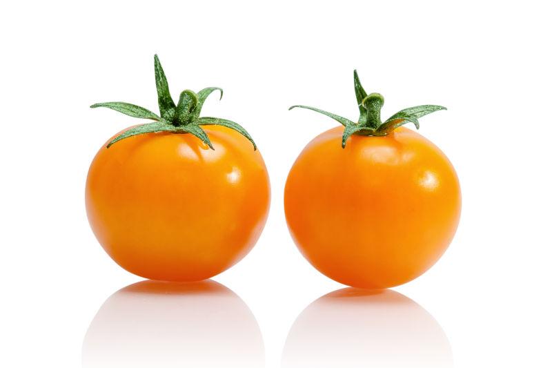 白色背景下两个黄色番茄