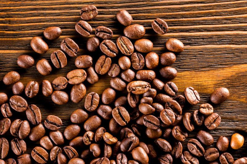 棕色木纹理背景上的咖啡豆