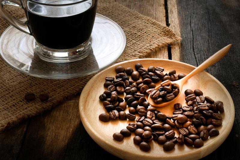 木纹理桌上的咖啡豆和一杯咖啡