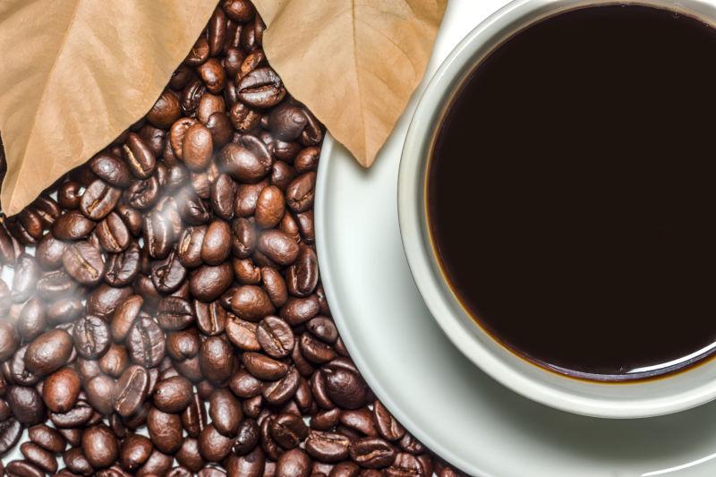咖啡豆背景上的一杯黑咖啡
