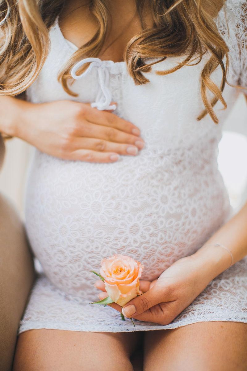 一位坐着的孕妇肚子上的玫瑰