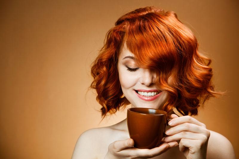 咖啡色头发女人手里拿着香浓的咖啡