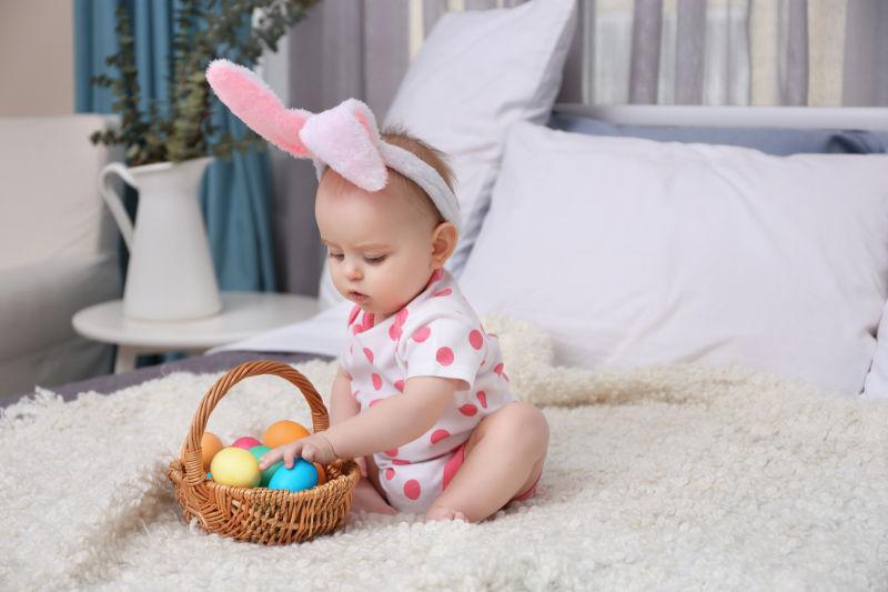 地毯上带着粉色兔耳朵的宝宝