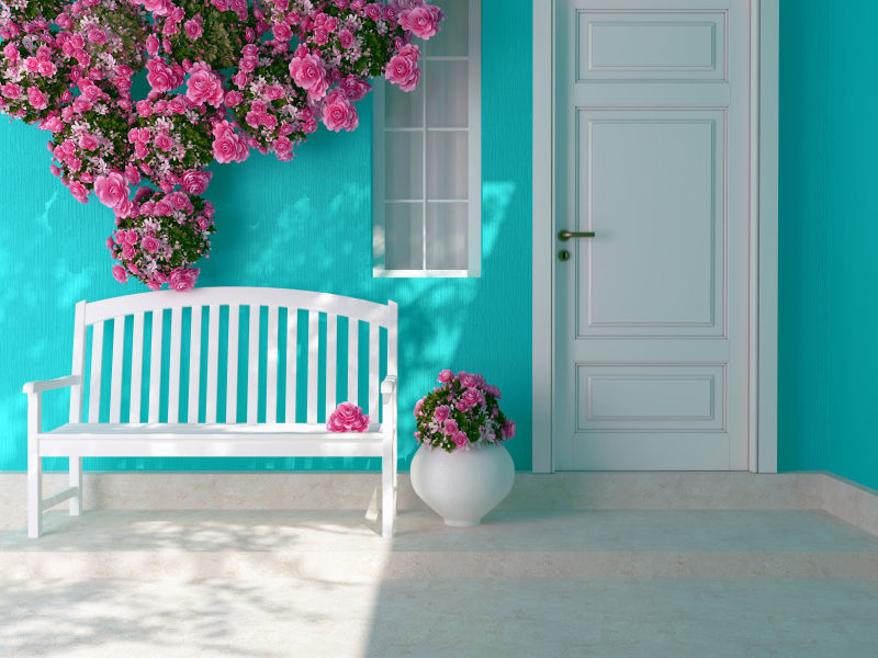 蓝色房子外的长凳和粉色玫瑰
