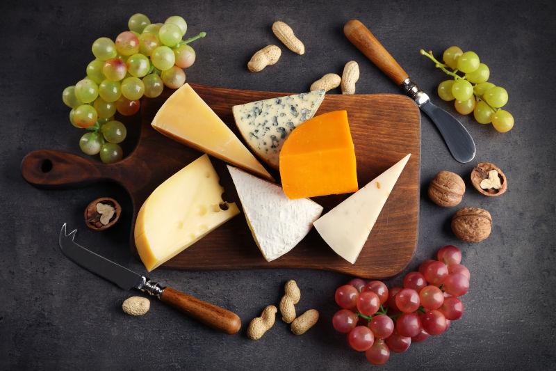 灰色背景下的各种奶酪和葡萄