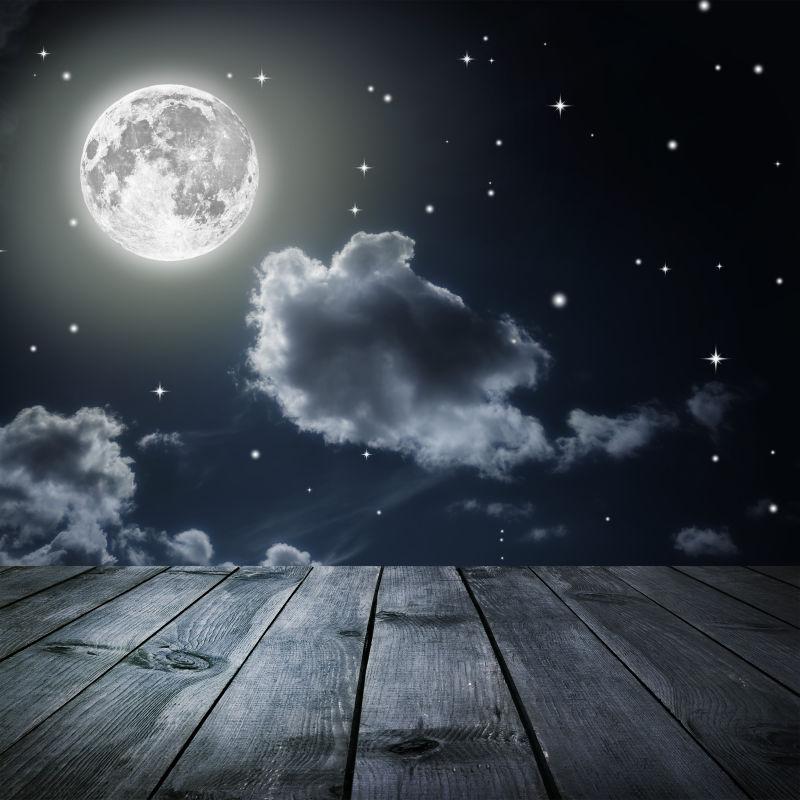 美丽的星星满月夜空背景前的木桌