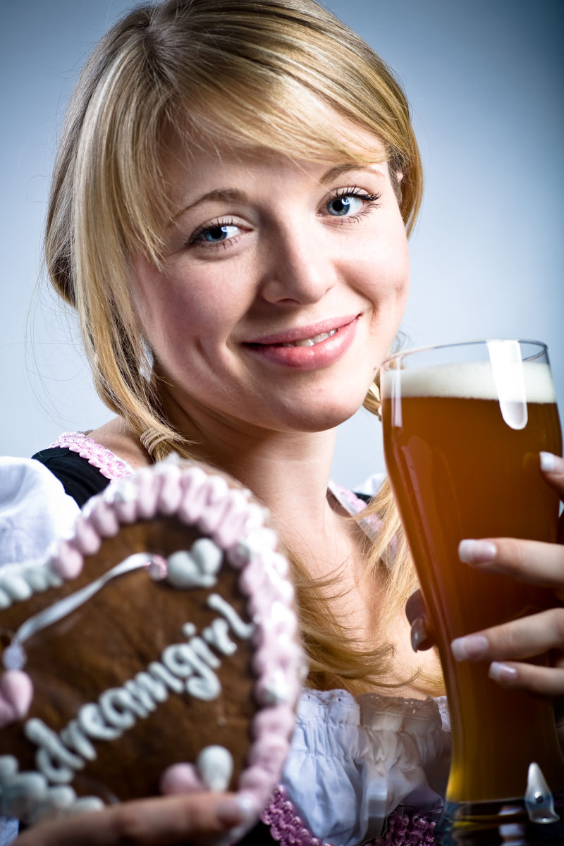 拿着啤酒的年轻的巴伐利亚女孩