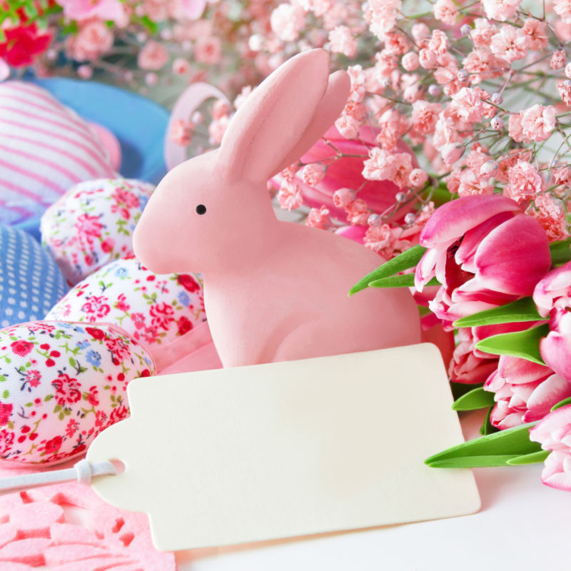 桌子上的郁金香和复活节彩蛋和玩具兔子