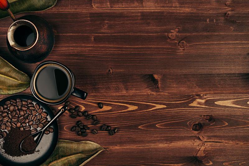 棕色的老木板背景上的黑咖啡和咖啡豆