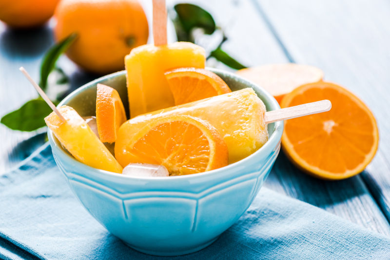 蓝色碗里的好吃的橙子棒冰