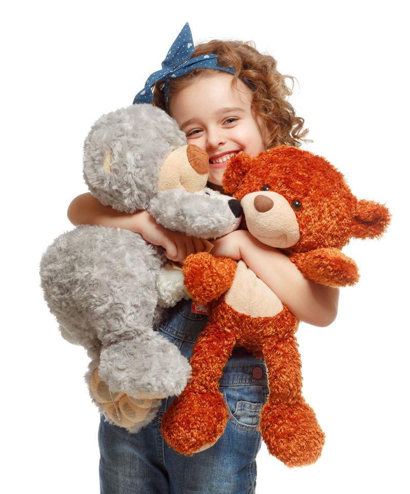 抱着两个玩具熊的女孩
