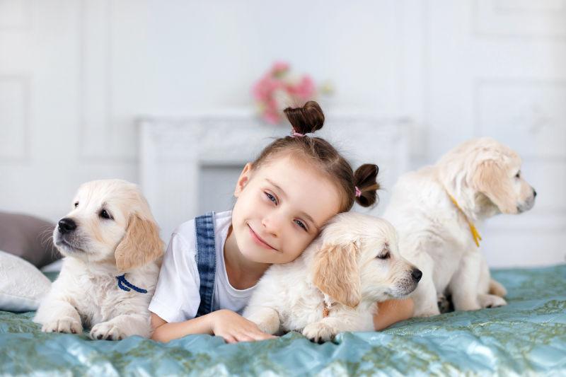 趴在地板上的小女孩和她的三只宠物狗