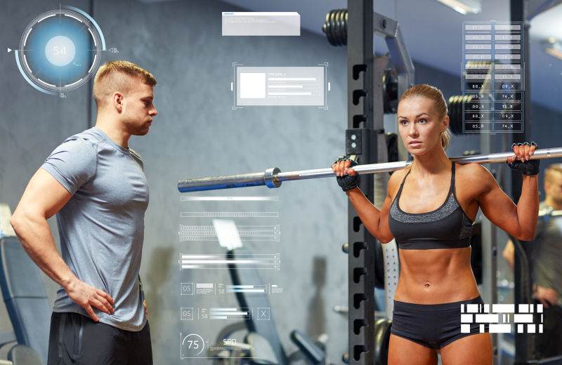 在健身房中用杠铃弯曲肌肉的男人和女人