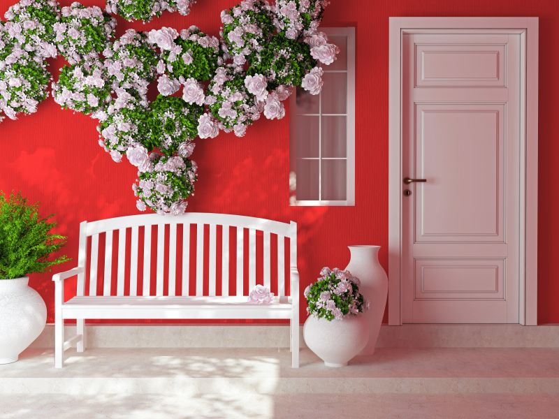 红色屋子外的长凳和粉红玫瑰