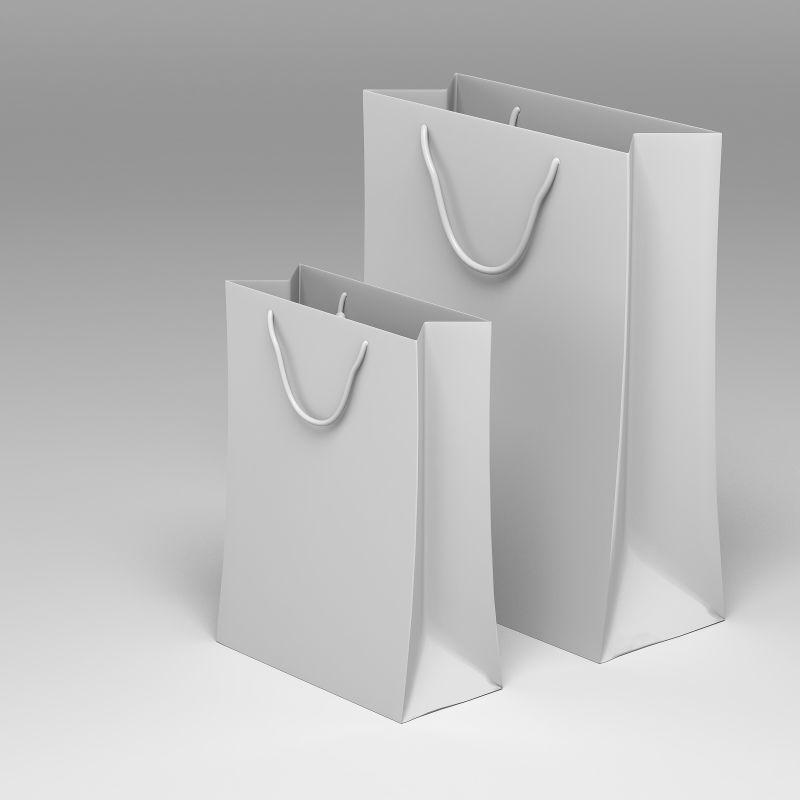 灰白色背景上的白色的一大一小的纸质购物袋