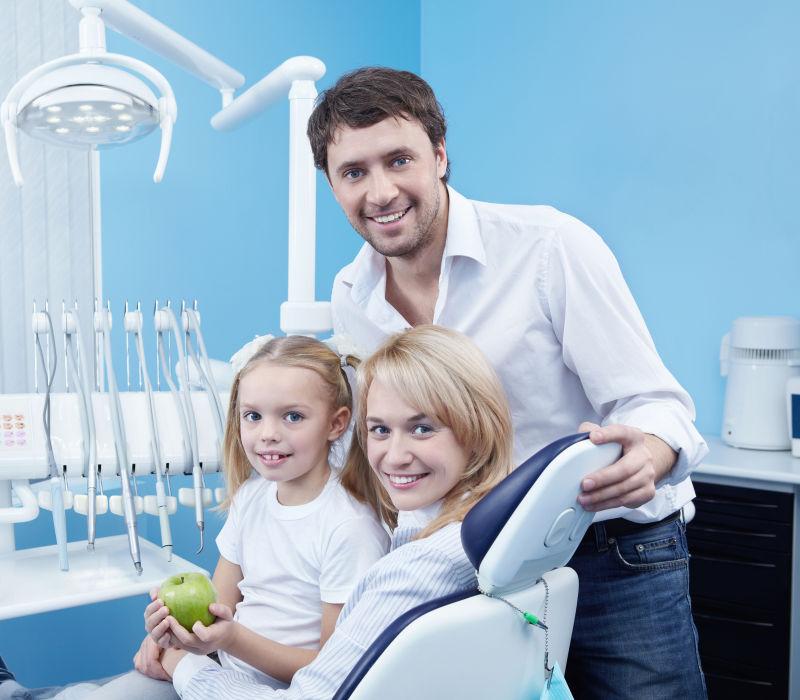 蓝色室内背景下一家三口带着孩子参观牙科诊所