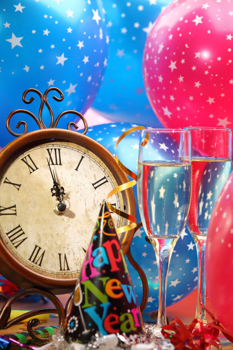 蓝色和红色气球背景下的时钟和香槟酒杯