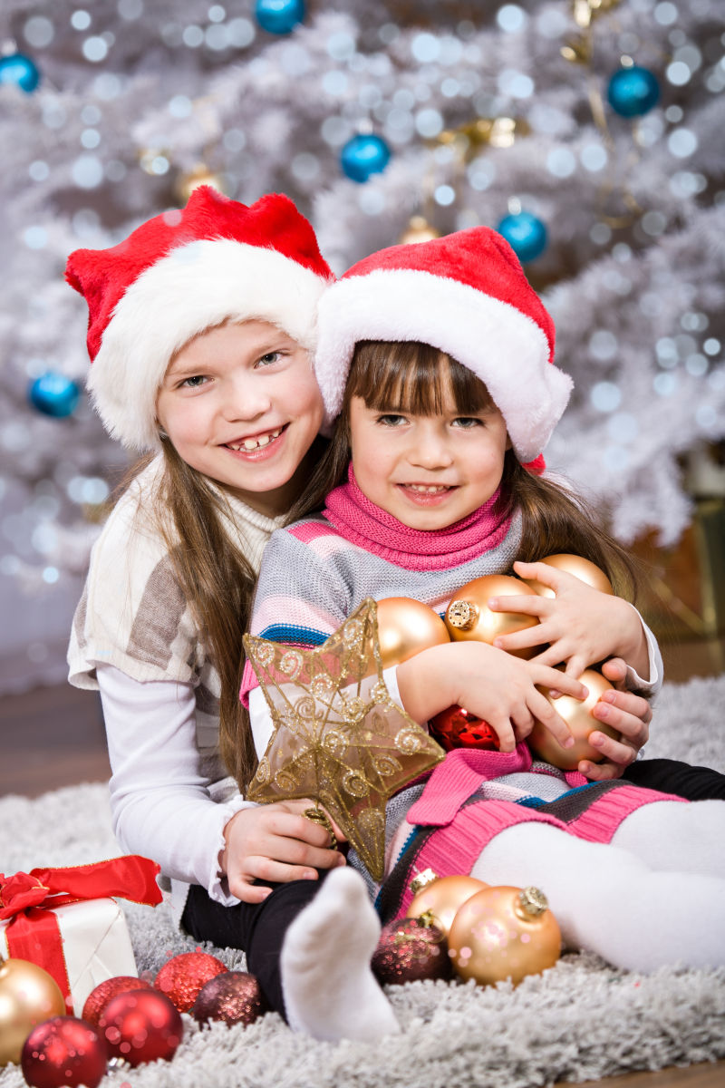 圣诞树背景中的两个小女孩