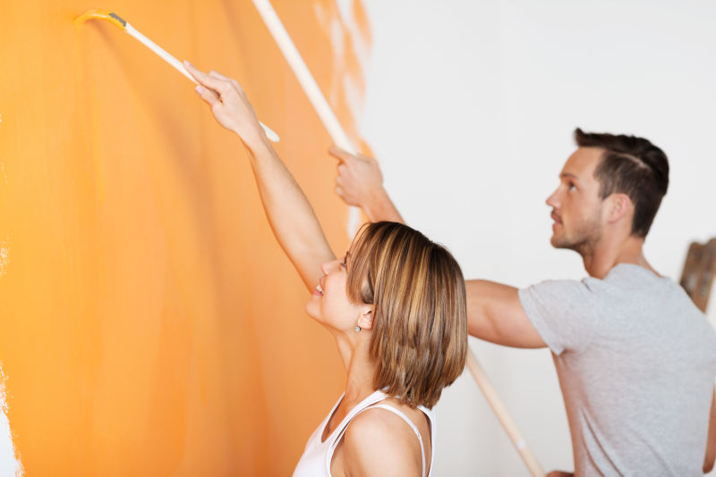 一对年轻夫妇在进行墙壁刷漆