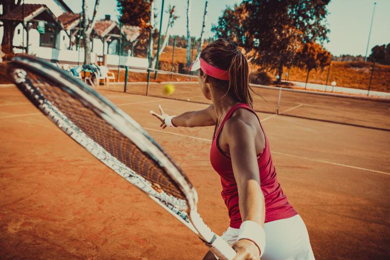 年轻女子在网球场上打网球