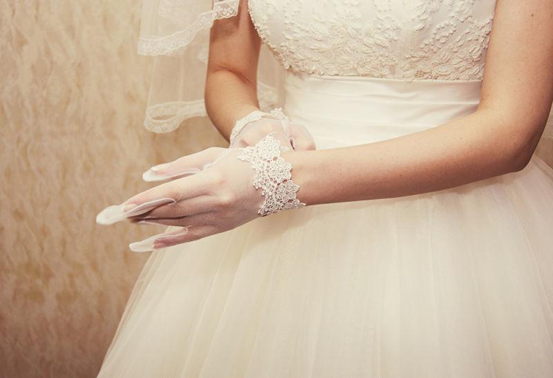 带着白色蕾丝手套的新娘