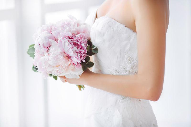 美丽的新娘手捧粉红色鲜花