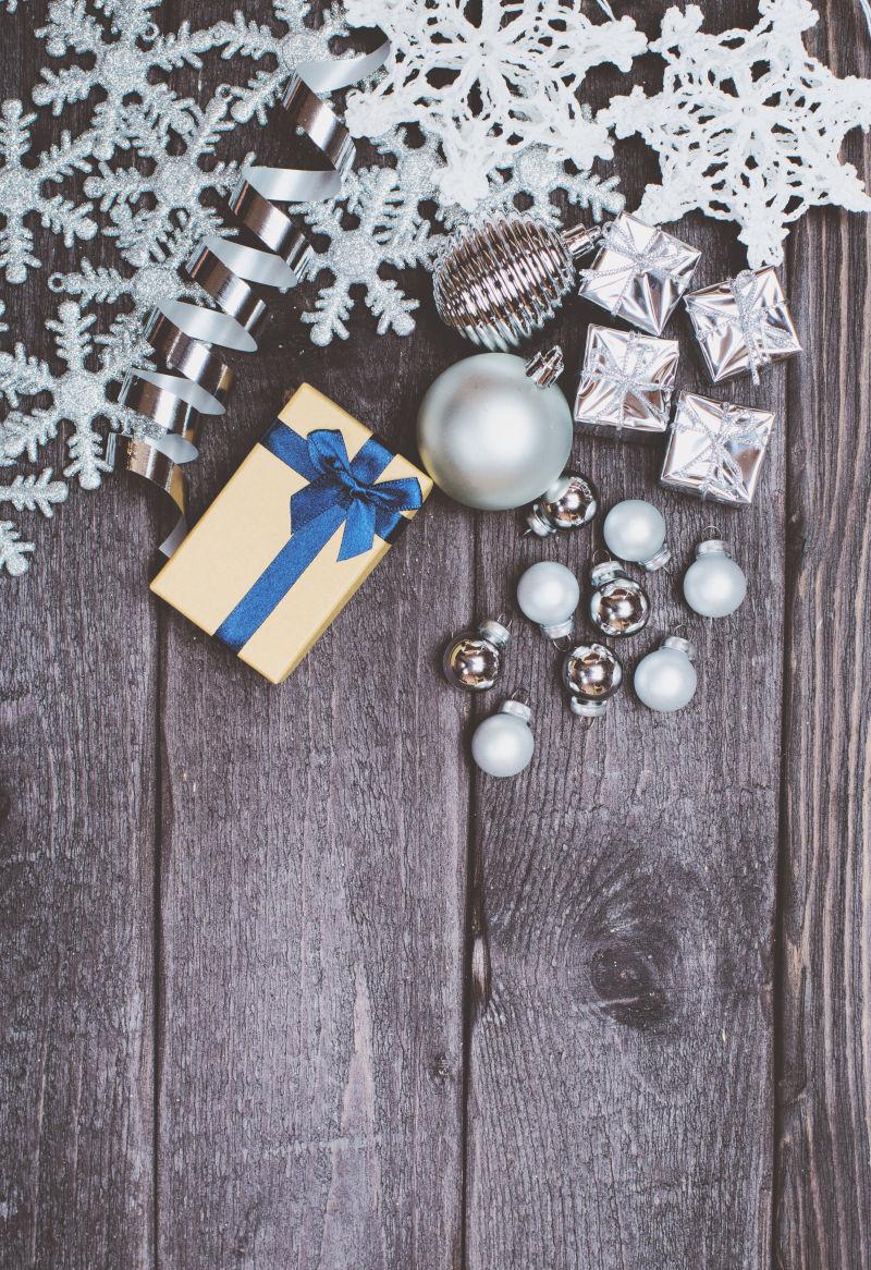 木制背景下的银圣诞装饰礼品盒和球